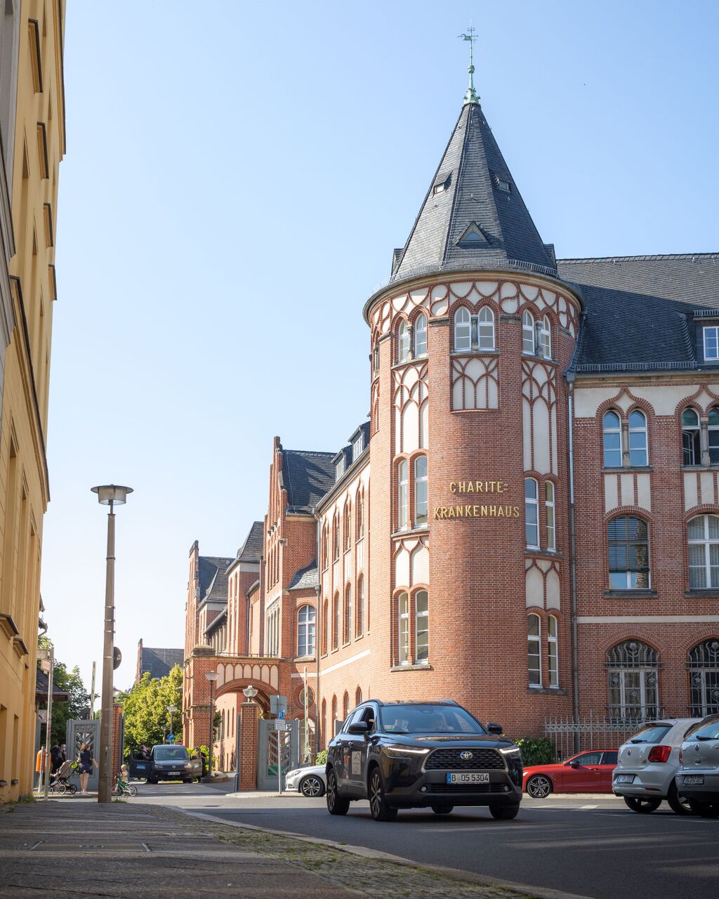 Backsteinfassade eines Universitätsklinikums mit Turm und Zufahrt